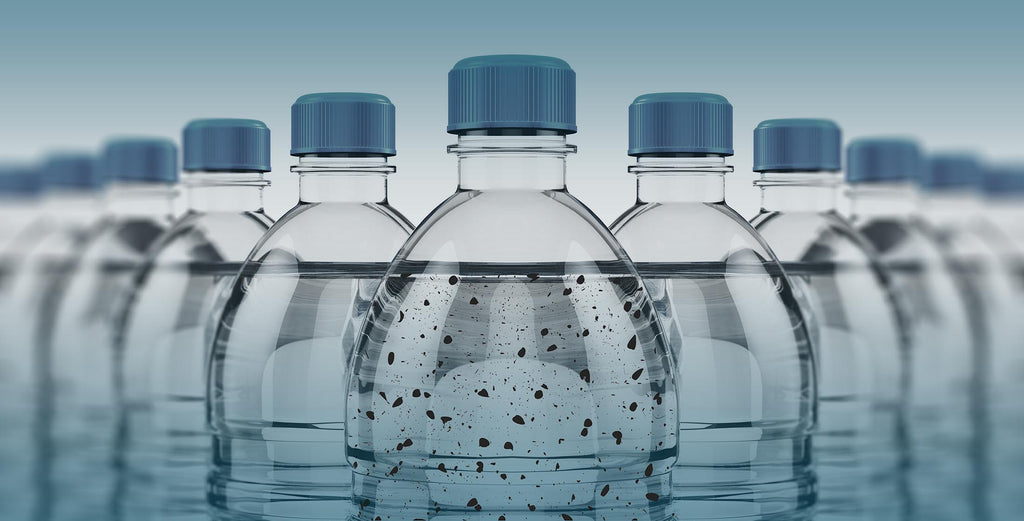 single use plastic bottles filled with water, with the main one containing microplastics inside the water, as banner for an eKodoKi blog article