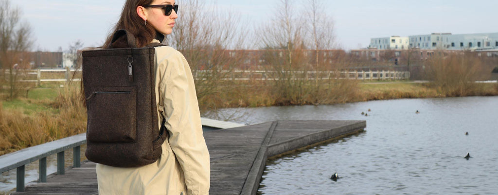 brown wool felt courier backpack carried by female model, used as desktop banner