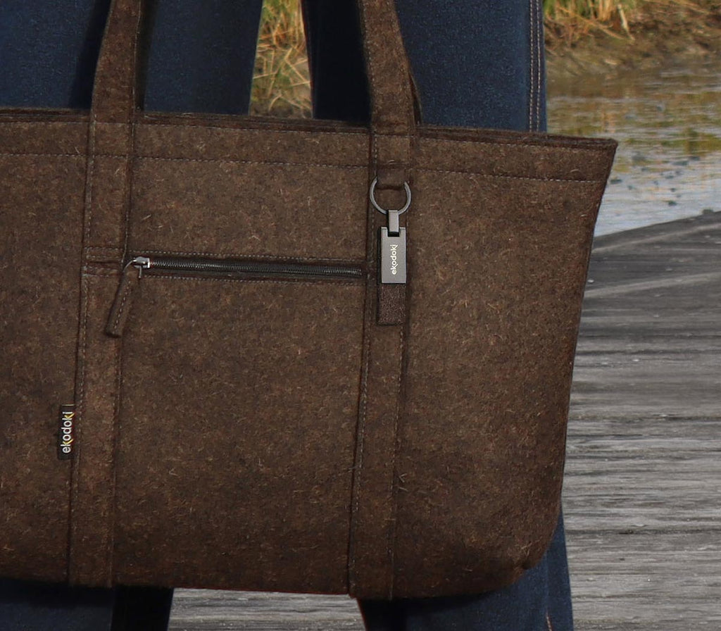 brown wool felt tote bag from the brand eKodoKi, in front of a woman's legs outside