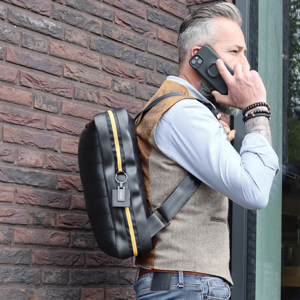 black seatbelt backpack L on male fashion model shoulders phoning with smartphone eKodoKi RE-BELT