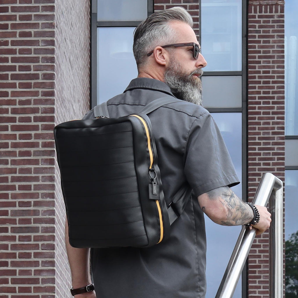 black seatbelt backpack L on male fashion model shoulders walking up the stairs eKodoKi RE-BELT