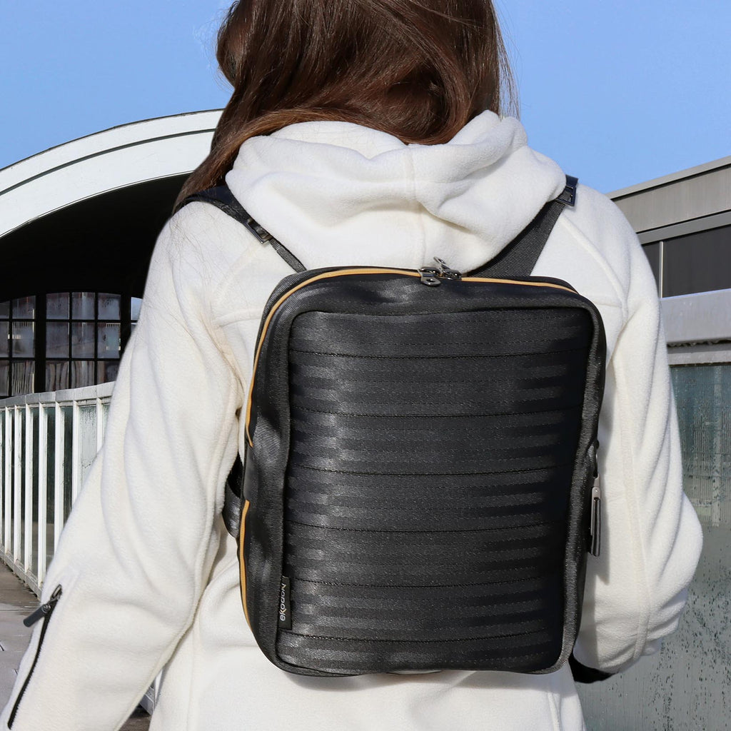 black seatbelt backpack M on female fashion model shoulders front view eKodoKi RE-BELT