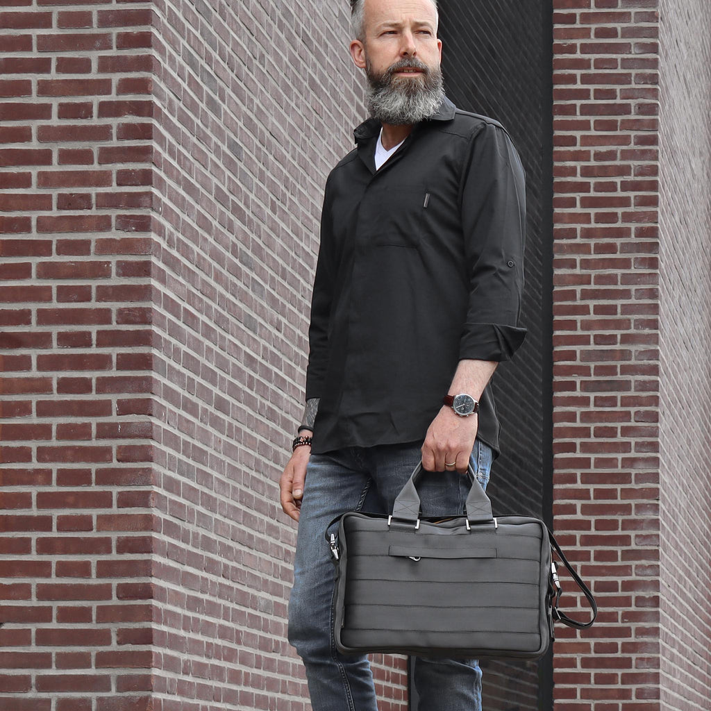 black seatbelt briefcase M on male fashion model in left hand standing eKodoKi RE-BELT