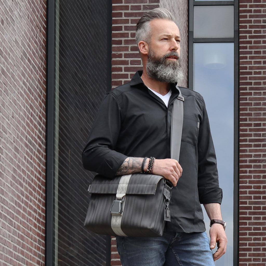 black seatbelt messenger bag M on male fashion model chest walking down the stairs eKodoKi RE-BELT