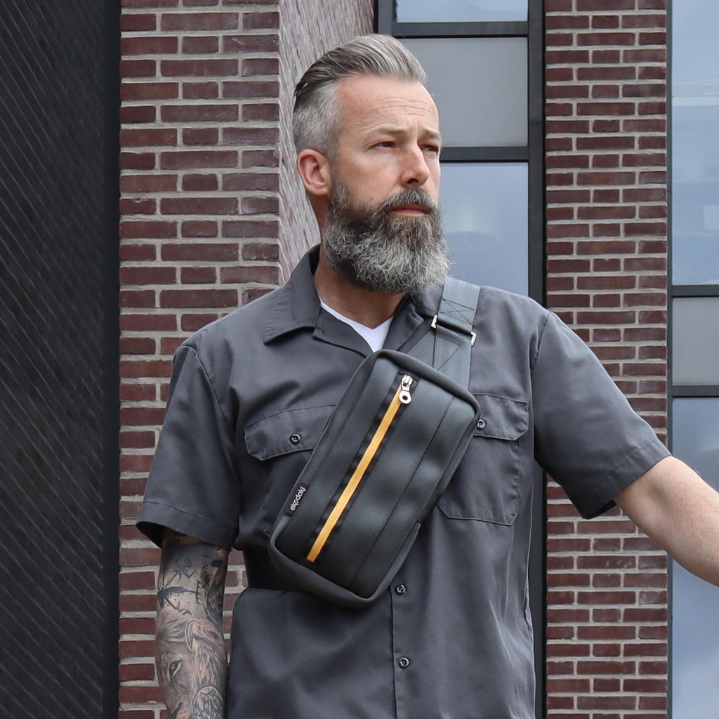 black seatbelt sling bag M on male fashion model chest walking down the stairs eKodoKi RE-BELT