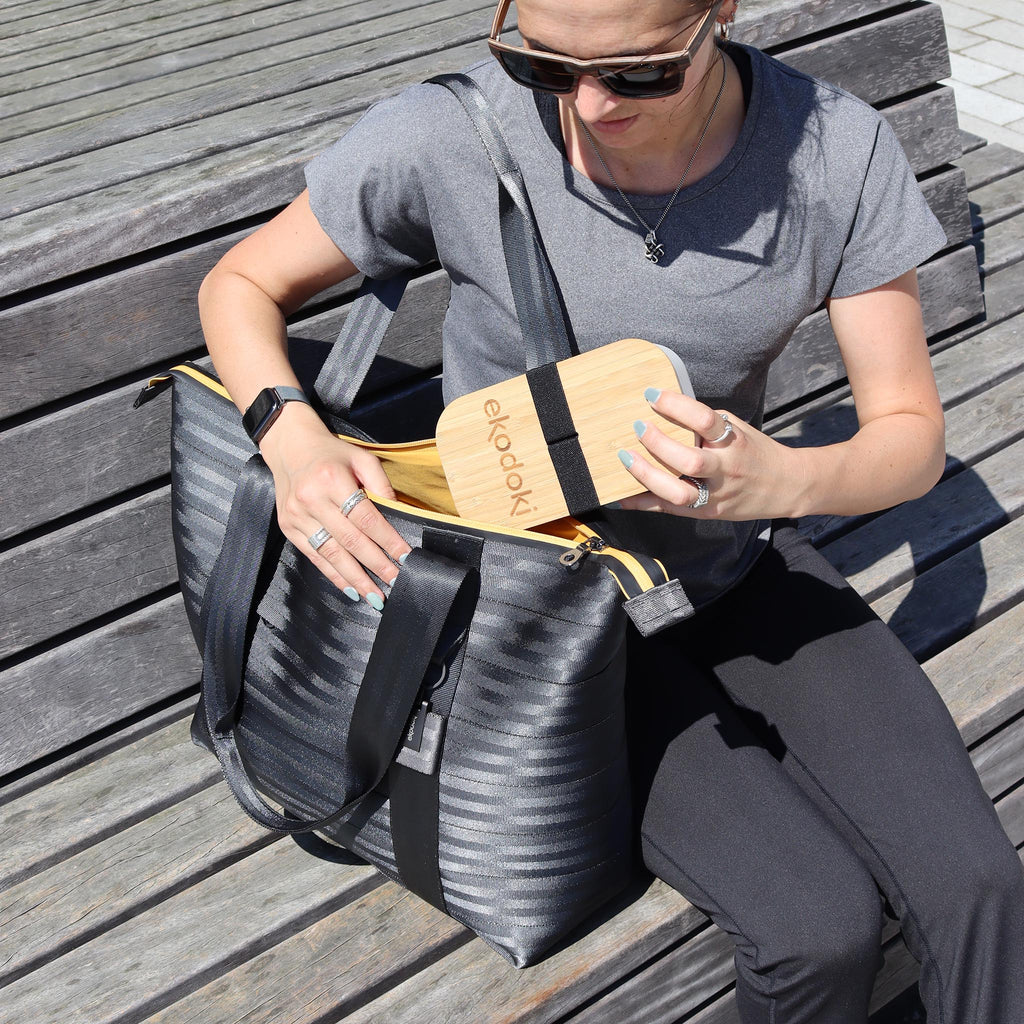black seatbelt tote bag L used by female fashion model, taking her bamboo lunchbox out eKodoKi RE-BELT