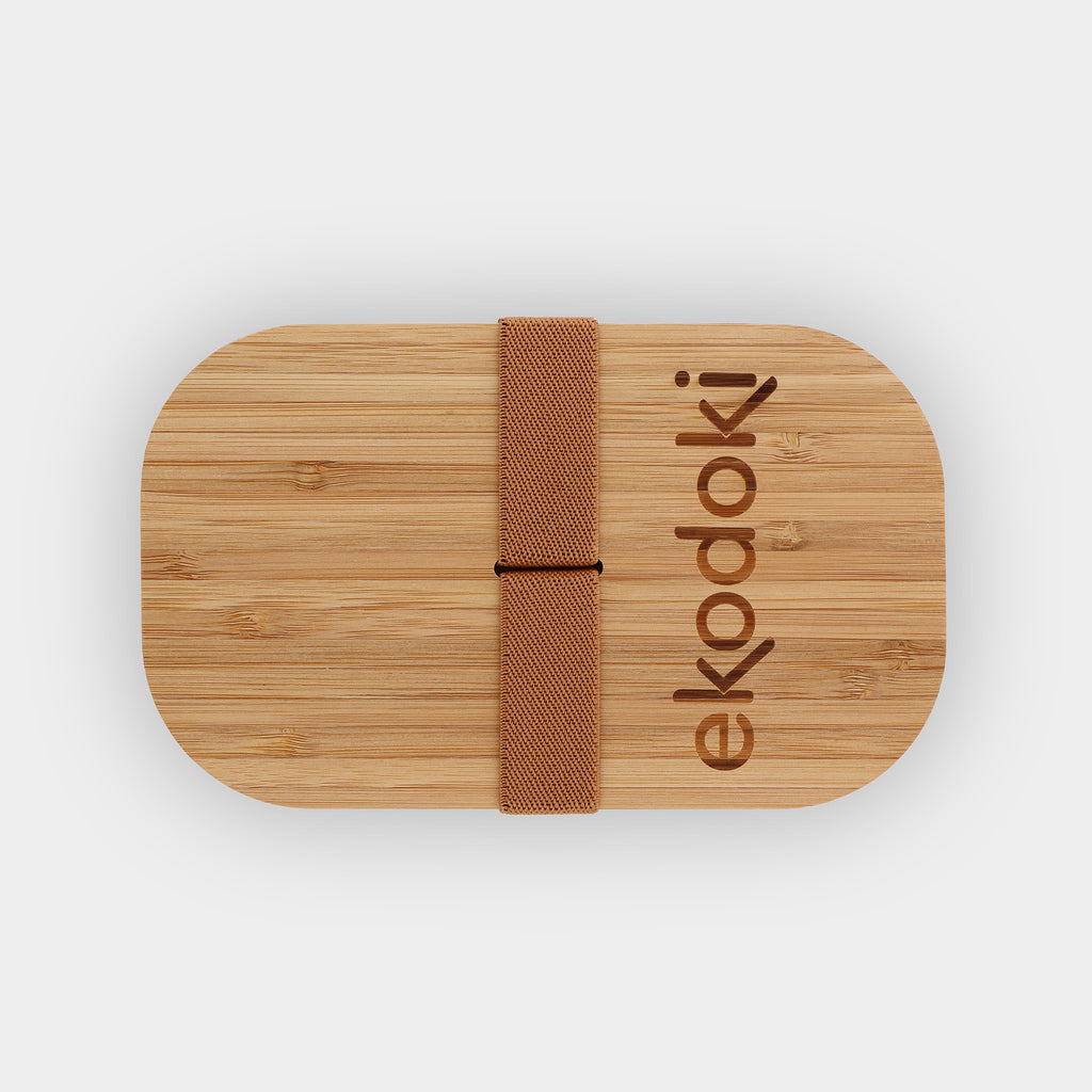 black lunchbox 1100ml 37oz with natural bamboo lid and built-in caramel elastic fabric strap wrapped around flatlay eKodoKi BENTO