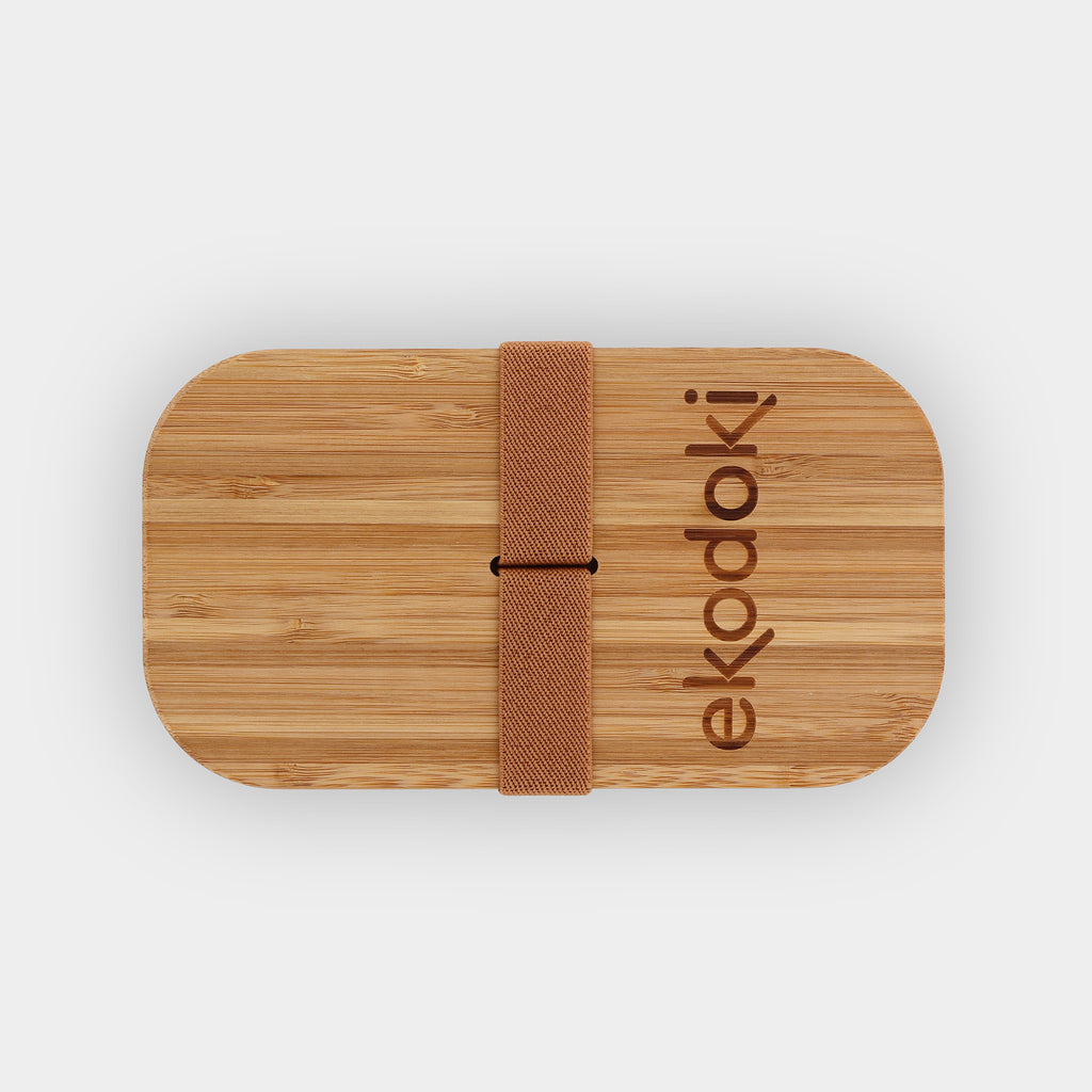 black lunchbox 700ml 24oz with natural bamboo lid and built-in caramel elastic fabric strap wrapped around flatlay eKodoKi BENTO
