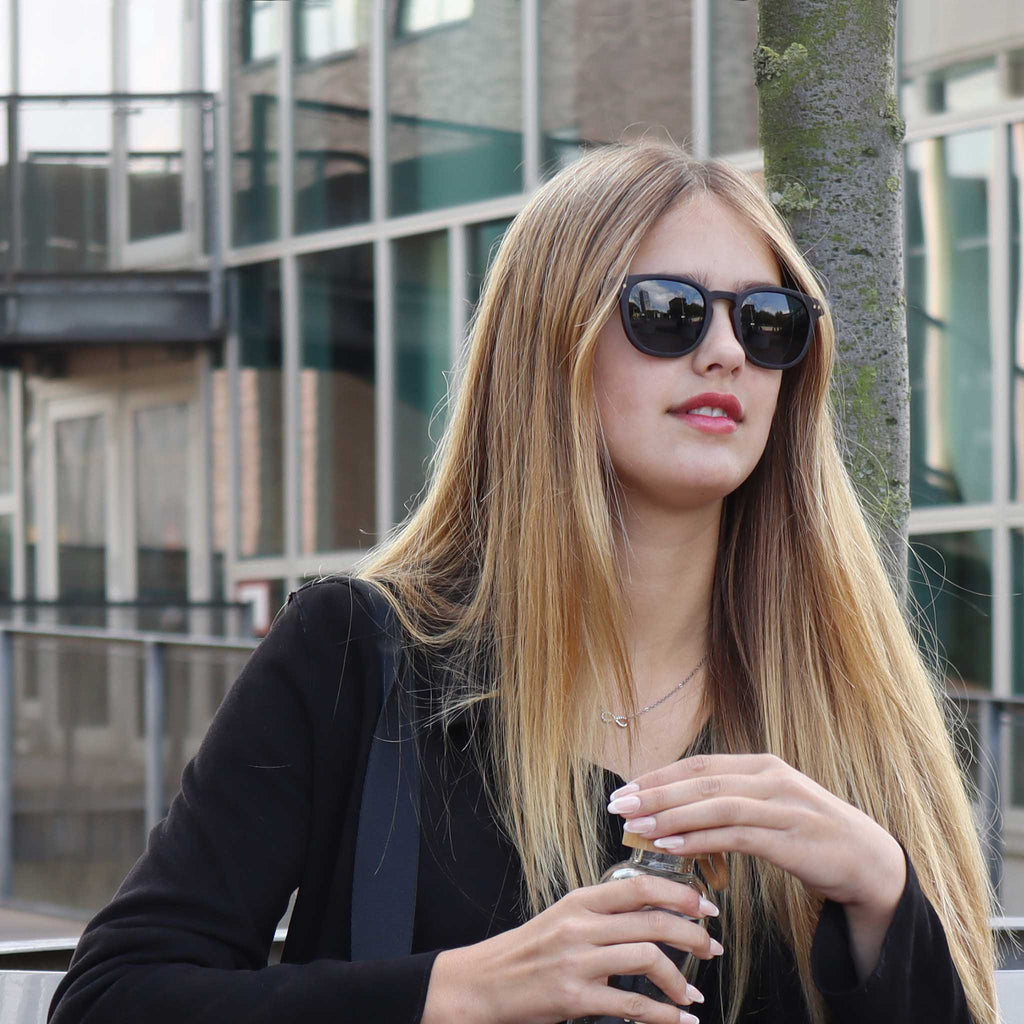 wooden sunglasses pantos style ebony wood smoke lenses on female fashion model opening a bottle eKodoKi COSMO